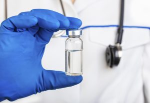 Doctor is holding glass bottle of medicine